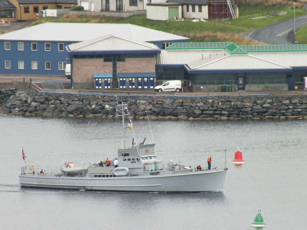 Photo of the restored sub-chaser HITRA coming into Scalloway harbour with the fisheries college in the background